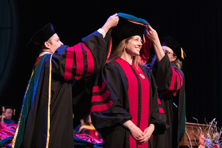 Graduate Kelly Kuehl receiving her hood onstage