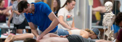 Students learn through simulating hands-on physical therapy practices with other students