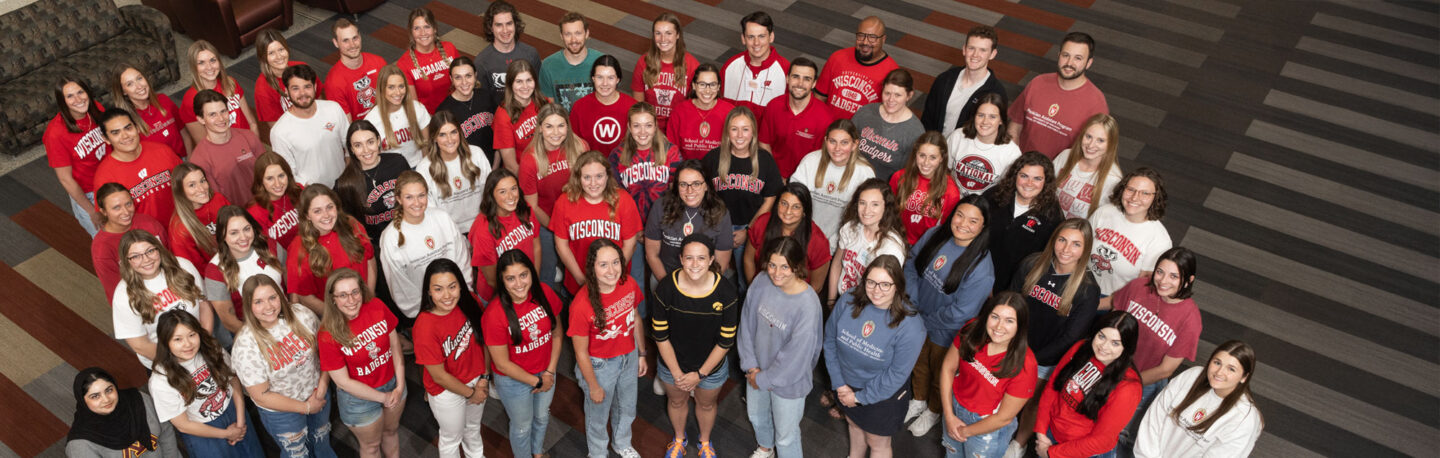 Smiling group of PA students pose with Bucky Badger