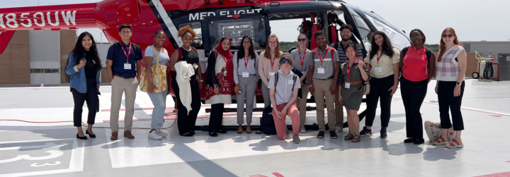 RUSCH students pose in front of a UW Med Flight helicopter