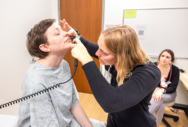 A medical student examines the nose of a standardized patient in the Clinical Teaching and Assessment Center (CTAC)